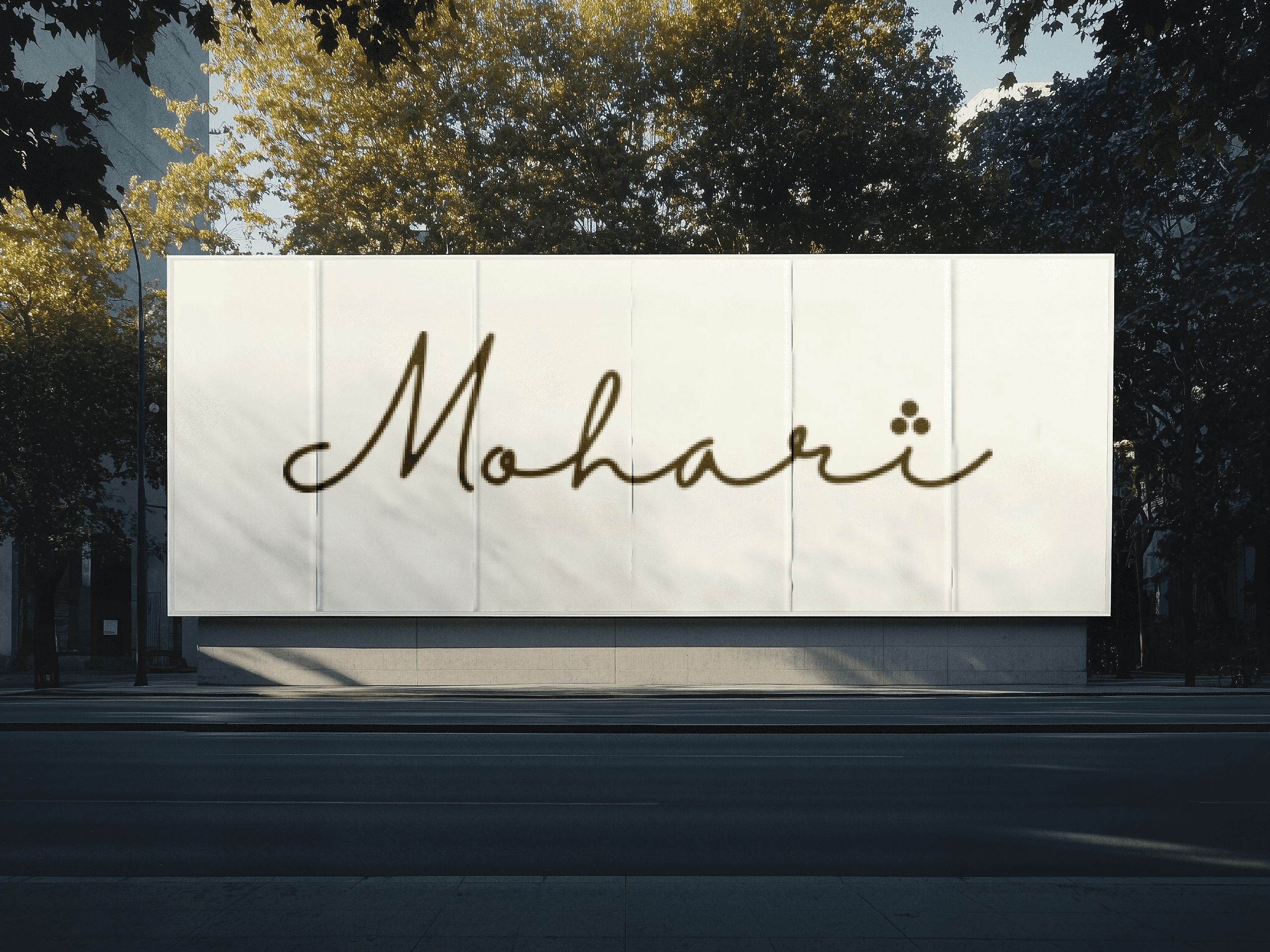 A large outdoor billboard with the text "Mohari" displayed in elegant, cursive script, set against a backdrop of lush trees and soft shadows from the late afternoon sunlight.